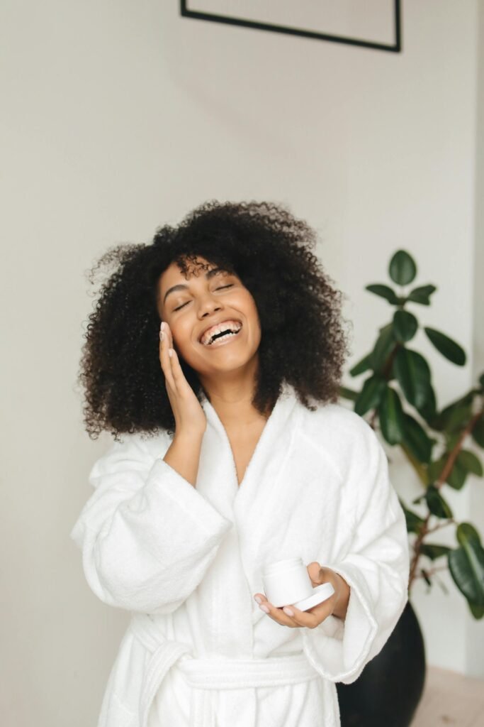 woman with her hand to face holding a jar of body body butter representing blog question should I use body butter on your face?